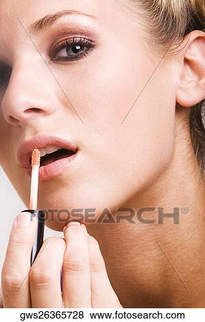 Portrait of a young woman applying lip liner View Large Photo Image Stock Photo - Portrait of a young woman applying lip liner. Fotosearch