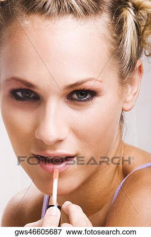 Portrait of a young woman applying lip liner View Large Photo Image Stock Photo - Portrait of a young woman applying lip liner. Fotosearch
