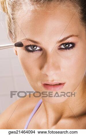 Portrait of a young woman applying eyeshadow View Large Photo Image Picture - Portrait of a young woman applying eyeshadow. Fotosearch