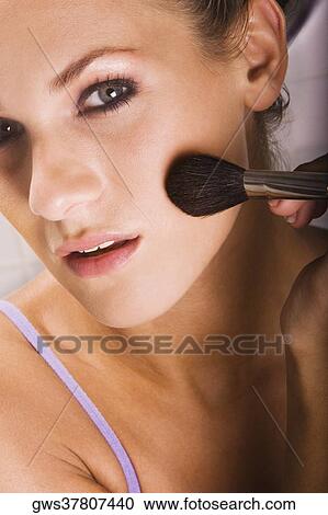 Portrait of a young woman applying blush with a brush View Large Photo Image Stock Image - Portrait of a young woman applying blush with a brush. Fotosearch