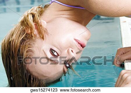 Portrait of a young woman bending forward with her hair in a swimming pool View Large Photo Image Stock Image - Portrait of a young woman bending forward with her hair in a swimming pool. Fotosearch