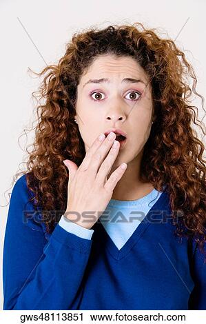 Portrait of a young woman covering her mouth with her hand View Large Photo Image Stock Image - Portrait of a young woman covering her mouth with her hand. Fotosearch