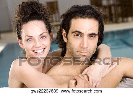 Portrait of a young woman embracing a mid adult man from behind View Large Photo Image Stock Photo - Portrait of a young woman embracing a mid adult man from behind. Fotosearch