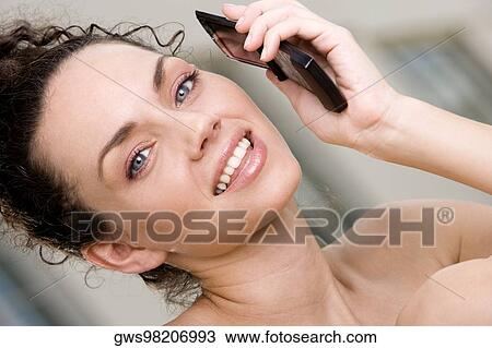Portrait of a young woman holding a mobile phone View Large Photo Image Stock Image - Portrait of a young woman holding a mobile phone. Fotosearch