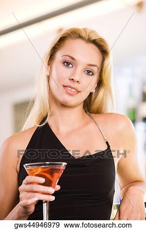 Portrait of a young woman holding a martini glass View Large Photo Image Stock Photo - Portrait of a young woman holding a martini glass. Fotosearch