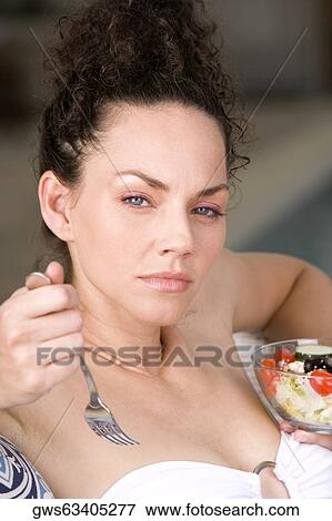 Portrait of a young woman holding a bowl of fruit salad and a fork View Large Photo Image Stock Photo - Portrait of a young woman holding a bowl of fruit salad and a fork. Fotosearch