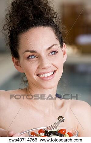Portrait of a young woman holding a bowl of fruit salad and a fork View Large Photo Image Stock Photograph - Portrait of a young woman holding a bowl of fruit salad and a fork. Fotosearch