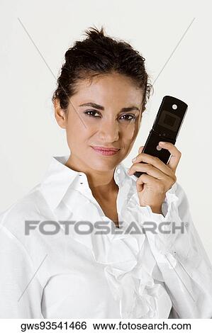 Stock Photograph - Portrait of a young woman holding a mobile phone. Fotosearch