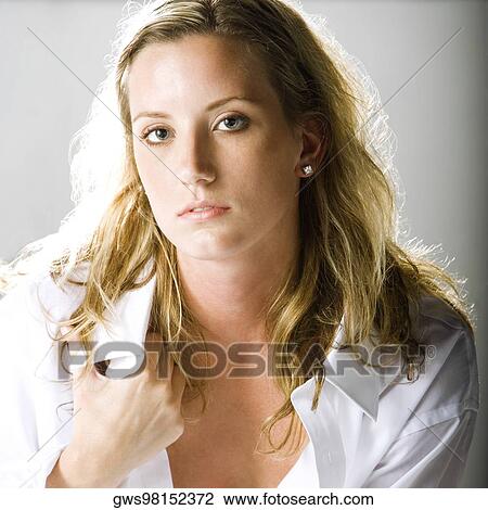 Portrait of a young woman holding her shirt collar View Large Photo Image Stock Image - Portrait of a young woman holding her shirt collar. Fotosearch