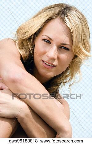 Portrait of a young woman hugging her knees View Large Photo Image Stock Photo - Portrait of a young woman hugging her knees. Fotosearch