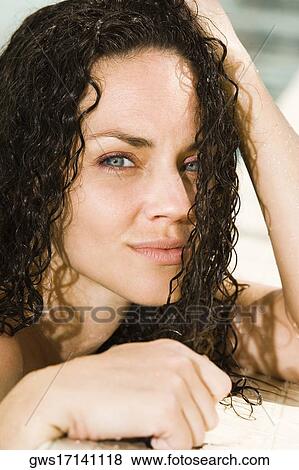 Portrait of a young woman leaning at the edge of a swimming pool View Large Photo Image Stock Photo - Portrait of a young woman leaning at the edge of a swimming pool. Fotosearch