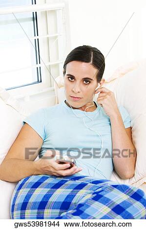 Portrait of a young woman listening to an MP3 player View Large Photo Image Picture - Portrait of a young woman listening to an MP3 player. Fotosearch