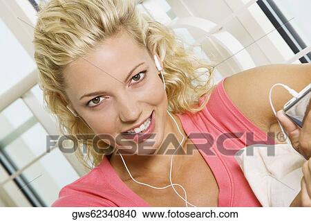 Portrait of a young woman listening to an MP3 player View Large Photo Image Stock Image - Portrait of a young woman listening to an MP3 player. Fotosearch