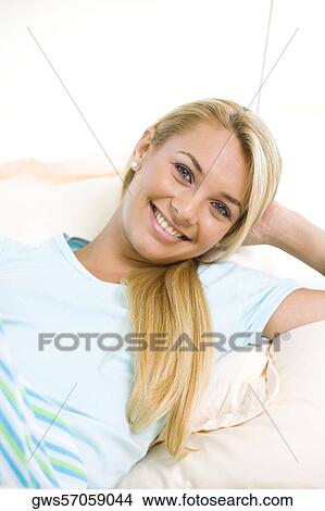 Portrait of a young woman lying down on a bed View Large Photo Image Picture - Portrait of a young woman lying down on a bed. Fotosearch