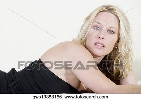Portrait of a young woman lying down View Large Photo Image Stock Photograph - Portrait of a young woman lying down. Fotosearch