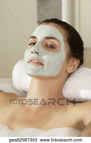 Portrait of a young woman lying in a bathtub wearing a facial mask View Large Photo Image Stock Image - Portrait of a young woman lying in a bathtub wearing a facial mask. Fotosearch