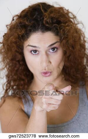 Stock Photo - Portrait of a young woman pointing forward. Fotosearch