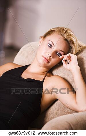 Portrait of a young woman reclining on an armchair View Large Photo Image Stock Image - Portrait of a young woman reclining on an armchair. Fotosearch