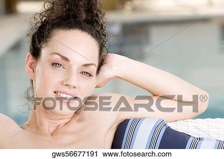 Portrait of a young woman relaxing at the poolside View Large Photo Image Stock Image - Portrait of a young woman relaxing at the poolside. Fotosearch