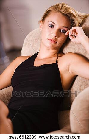 Portrait of a young woman resting on an arm chair View Large Photo Image Stock Photo - Portrait of a young woman resting on an arm chair. Fotosearch