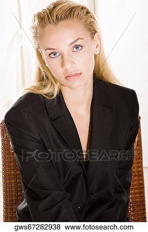 Portrait of a young woman sitting on a chair View Large Photo Image Stock Photo - Portrait of a young woman sitting on a chair. Fotosearch