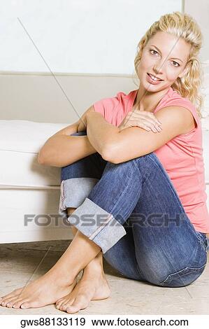 Portrait of a young woman sitting on the floor View Large Photo Image Stock Photo - Portrait of a young woman sitting on the floor. Fotosearch