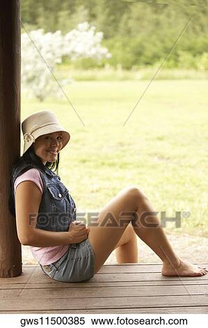 Portrait of a young woman sitting on the floor smiling View Large Photo Image Stock Photography - Portrait of a young woman sitting on the floor smiling. Fotosearch