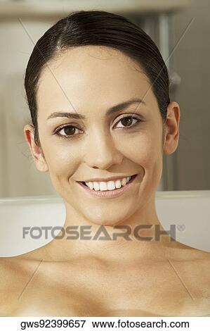 Stock Photo - Portrait of a young woman smiling in a bathtub. Fotosearch