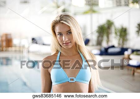 Stock Photograph - Portrait of a young woman standing at the poolside. Fotosearch