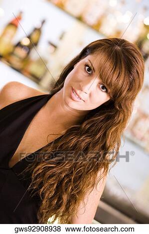 Portrait of a young woman standing in front of a bar counter View Large Photo Image Stock Photo - Portrait of a young woman standing in front of a bar counter. Fotosearch