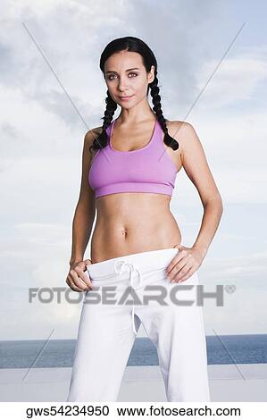 Portrait of a young woman standing with her hands on her hips View Large Photo Image Stock Image - Portrait of a young woman standing with her hands on her hips. Fotosearch