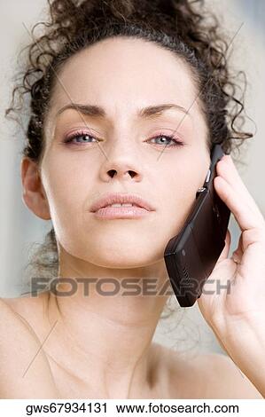 Stock Image - Portrait of a young woman talking on a mobile phone. Fotosearch