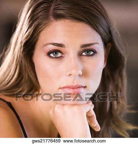 Portrait of a young woman thinking with her hand under her chin View Large Photo Image Stock Photo - Portrait of a young woman thinking with her hand under her chin. Fotosearch