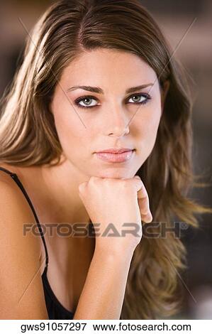 Portrait of a young woman thinking with her hand under her chin View Large Photo Image Stock Photo - Portrait of a young woman thinking with her hand under her chin. Fotosearch