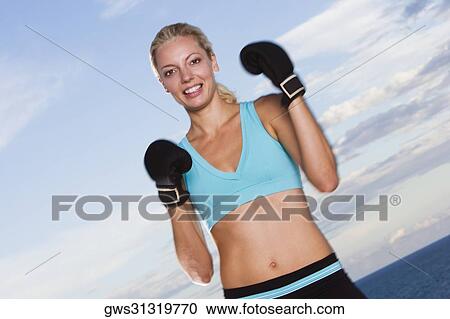 Portrait of a young woman wearing boxing gloves View Large Photo Image Stock Image - Portrait of a young woman wearing boxing gloves. Fotosearch