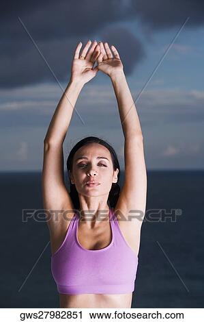 Portrait of a young woman with her arms raised View Large Photo Image Stock Image - Portrait of a young woman with her arms raised. Fotosearch