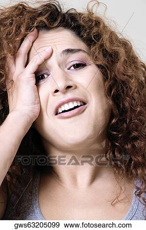 Portrait of a young woman with her hand on her head View Large Photo Image Stock Photo - Portrait of a young woman with her hand on her head. Fotosearch