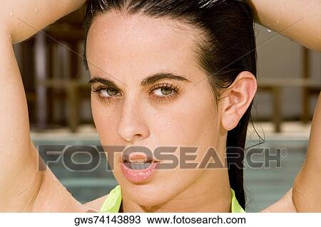 Portrait of a young woman with her hands behind her head View Large Photo Image Stock Image - Portrait of a young woman with her hands behind her head. Fotosearch