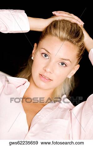 Portrait of a young woman with her hands on her head View Large Photo Image Stock Photo - Portrait of a young woman with her hands on her head. Fotosearch