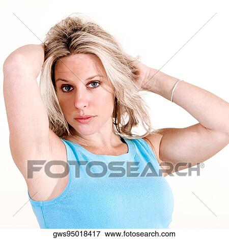 Portrait of a young woman with her hands behind her head View Large Photo Image Stock Photo - Portrait of a young woman with her hands behind her head. Fotosearch