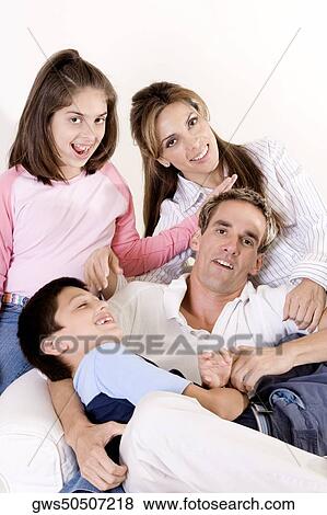 Portrait of parents sitting with their son and daughter on an armchair View Large Photo Image Stock Photo - Portrait of parents sitting with their son and daughter on an armchair. Fotosearch