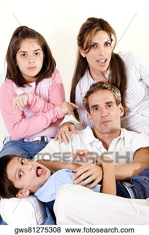 Stock Photo - Portrait of parents sitting with their son and daughter. Fotosearch