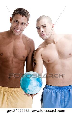 Portrait of two young men standing with a ball View Large Photo Image Stock Image - Portrait of two young men standing with a ball. Fotosearch