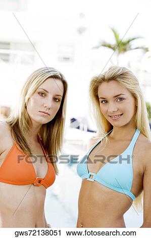 Portrait of two young women standing at the poolside View Large Photo Image Stock Image - Portrait of two young women standing at the poolside. Fotosearch