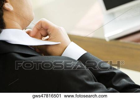 Rear view of a businessman adjusting his tie View Large Photo Image Stock Image - Rear view of a businessman adjusting his tie. Fotosearch