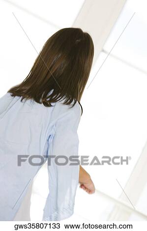 Rear view of a girl standing in front of a window View Large Photo Image Stock Image - Rear view of a girl standing in front of a window. Fotosearch