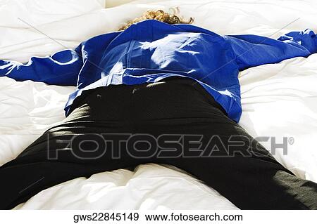 Rear view of a mid adult man lying on the bed View Large Photo Image Stock Photo - Rear view of a mid adult man lying on the bed. Fotosearch