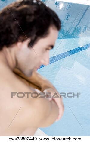 Rear view of a mid adult man sitting at the poolside View Large Photo Image Stock Photo - Rear view of a mid adult man sitting at the poolside. Fotosearch