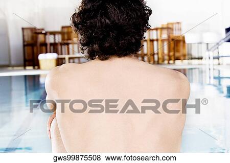 Rear view of a mid adult man sitting at the poolside View Large Photo Image Stock Photo - Rear view of a mid adult man sitting at the poolside. Fotosearch