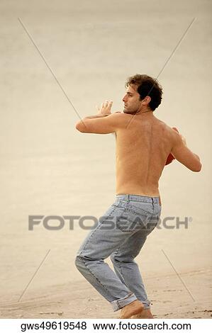Rear view of a mid adult man throwing a rugby ball View Large Photo Image Stock Photo - Rear view of a mid adult man throwing a rugby ball. Fotosearch